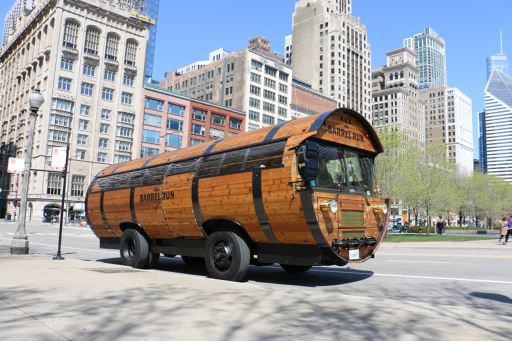 angle of The Barrel Run Chicago bus with tall buildings in the background