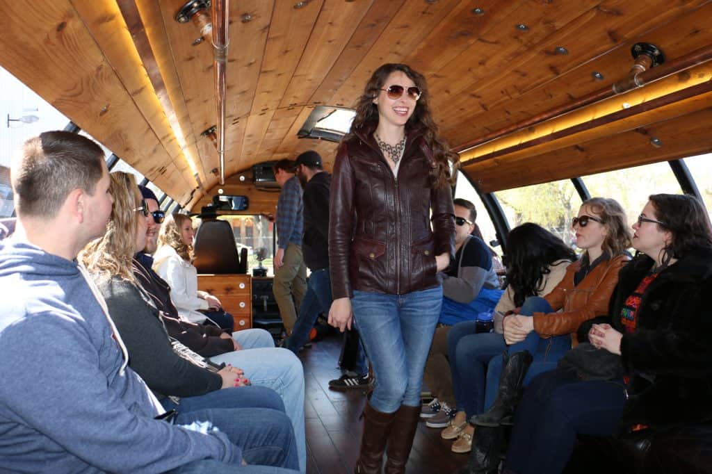people sitting looking at a lady wearing sunglasses in the barrel bus